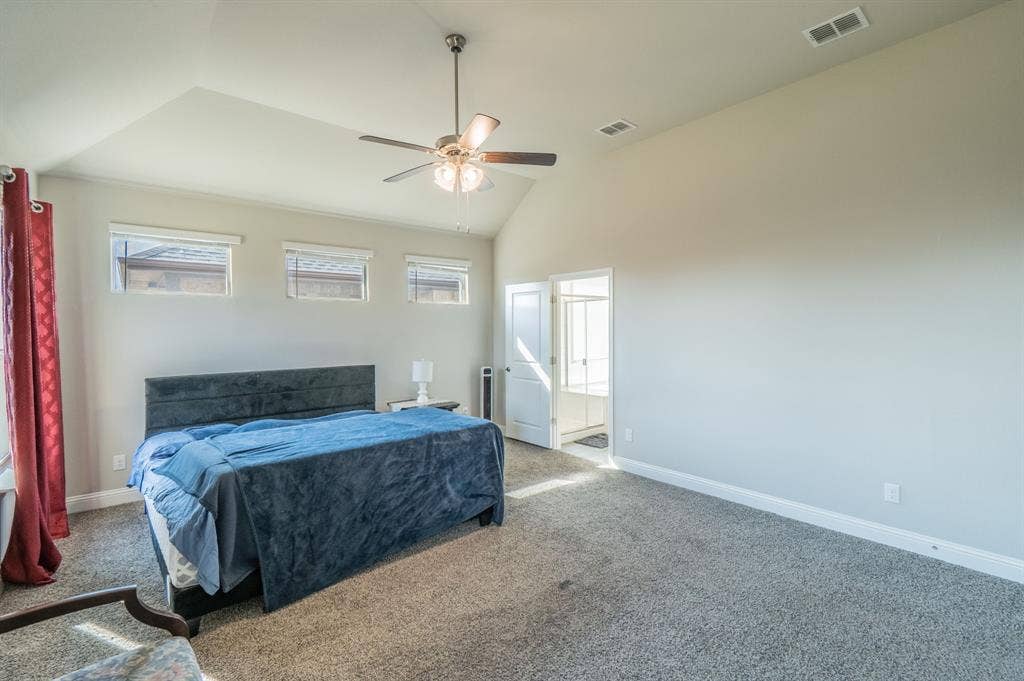 2041 St Andrews Way, Argyle, TX 76226 Vaulted ceiling, ceiling fan with integrated lighting, three transom windows, and carpeted flooring