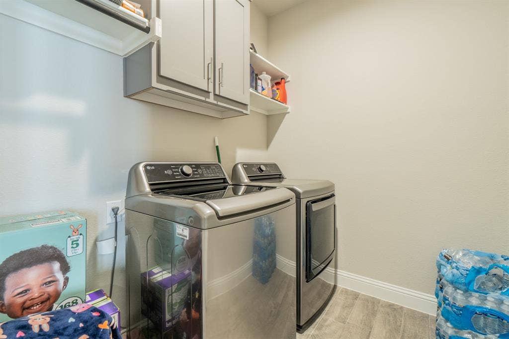 2041 St Andrews Way, Argyle, TX 76226 Built-in cabinetry with silver hardware, wall-mounted shelving, wood-finish flooring, and white wall paint