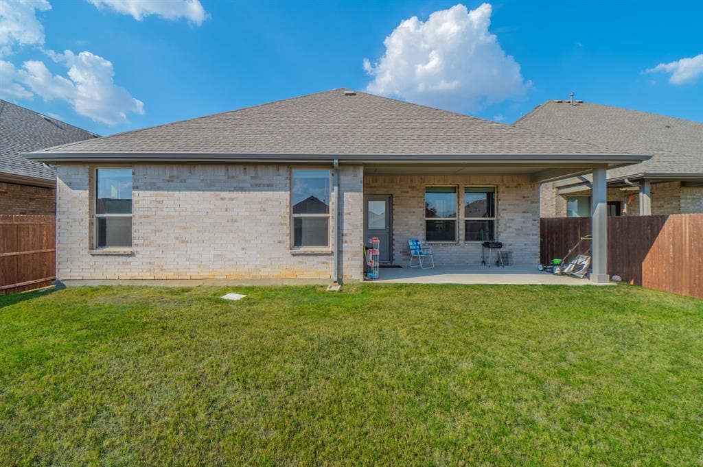 2041 St Andrews Way, Argyle, TX 76226 Brick exterior with a covered patio, shingle roof, and a fenced yard