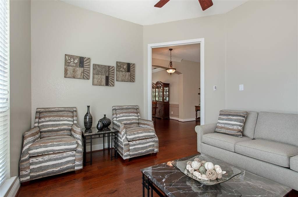Wood-finish flooring, neutral wall tones, and an open doorway to an adjacent room