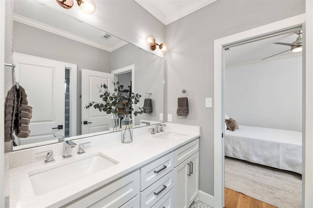 Dual vanity with white cabinetry and chrome hardware, featuring undermount sinks and a stone-finish countertop