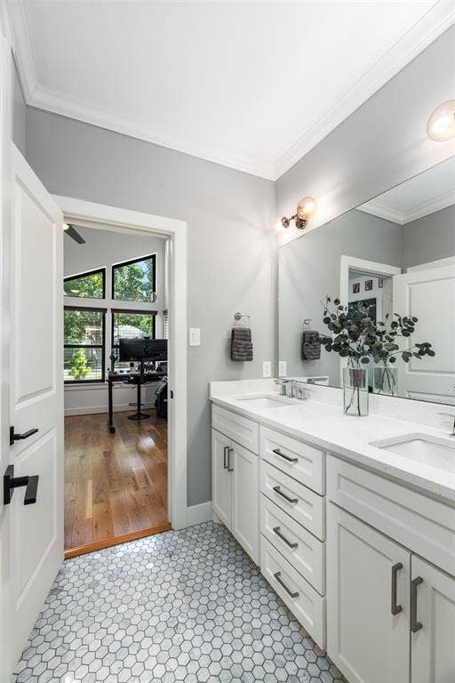 Dual vanity with undermount sinks and white countertops, hexagonal floor tiling, and a large wall-mounted mirror