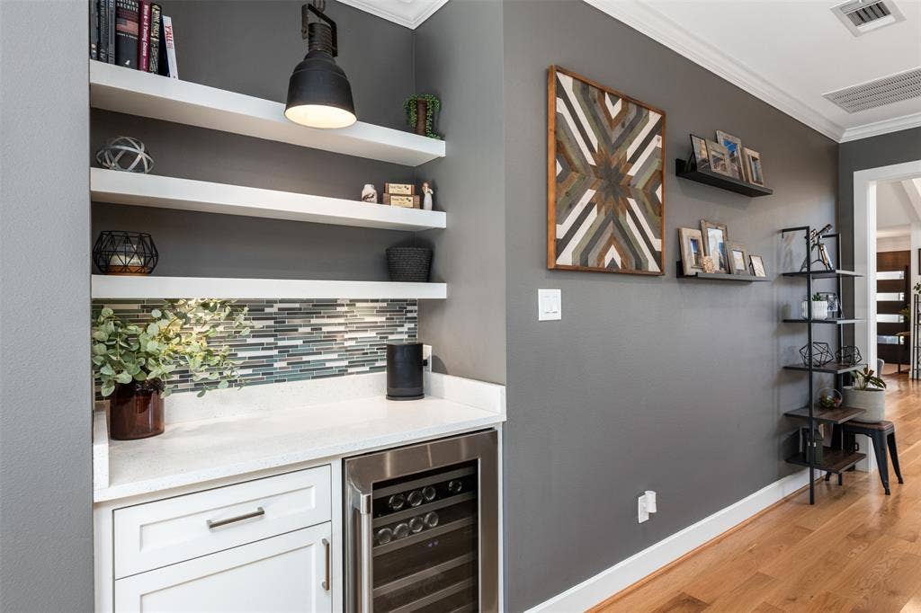 Built-in bar with white cabinetry, white countertop, and mosaic tile backsplash