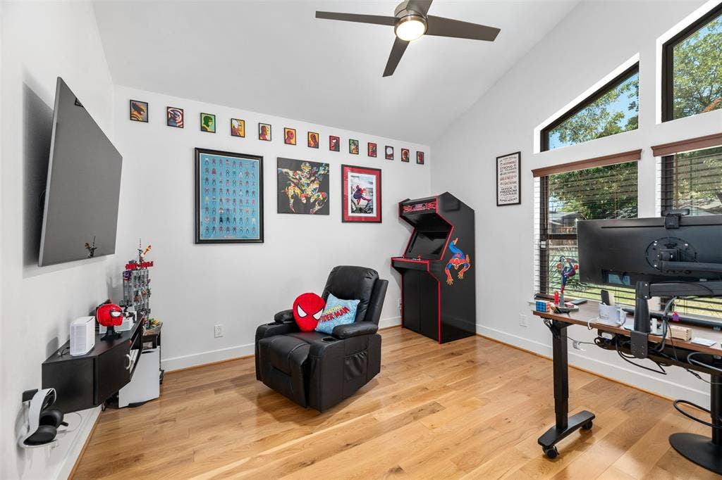 3rd bedroom, Vaulted ceiling with a contemporary ceiling fan, prominent windows, and wood-finish flooring