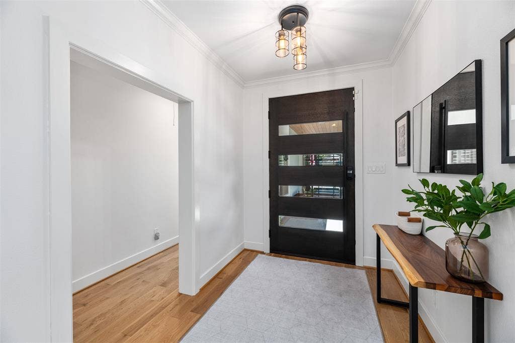 Modern entryway featuring a contemporary front door with multiple glass inserts, wood-finish flooring, recessed lighting, and a linear accent mirror