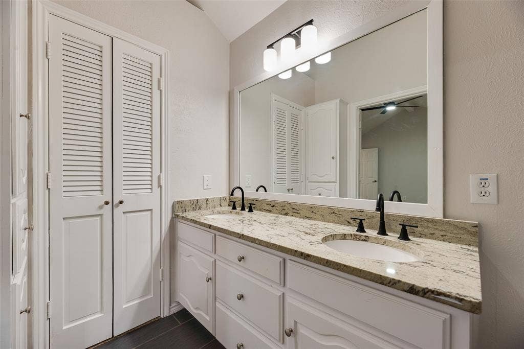 Dual vanity with a stone countertop, undermount sinks, and matte black fixtures