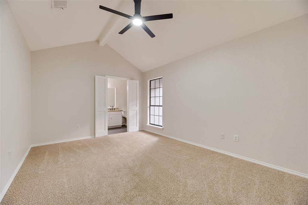 Vaulted ceiling, carpet flooring, ceiling fan, and double-pane window