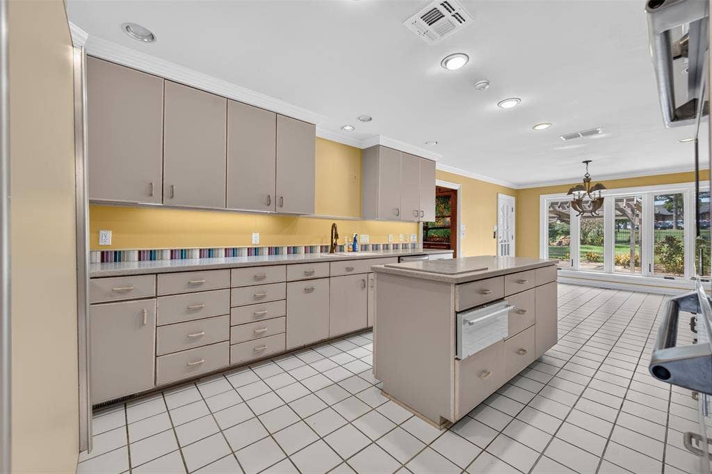 702 Mulberry Drive, Athens, TX 75751 Kitchen with recessed lighting, a center island, extensive cabinetry, a tiled floor, and a large window overlooking the exterior