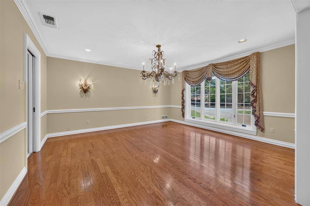 702 Mulberry Drive, Athens, TX 75751 Hardwood flooring, decorative chair rail molding, crown molding, built-in recessed lighting, and a crystal chandelier