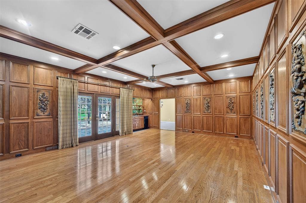 702 Mulberry Drive, Athens, TX 75751 Hardwood flooring throughout, coffered ceiling with recessed lighting, full wood paneling, decorative wall carvings, and French doors
