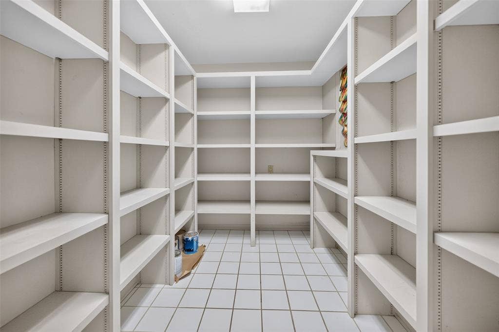 702 Mulberry Drive, Athens, TX 75751 Expansive pantry featuring extensive built-in shelving, white tile flooring, and overhead lighting