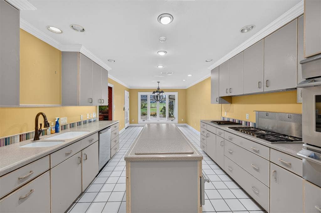 702 Mulberry Drive, Athens, TX 75751 Galley kitchen featuring a gas range, built-in oven, recessed lighting, center island, and tile flooring