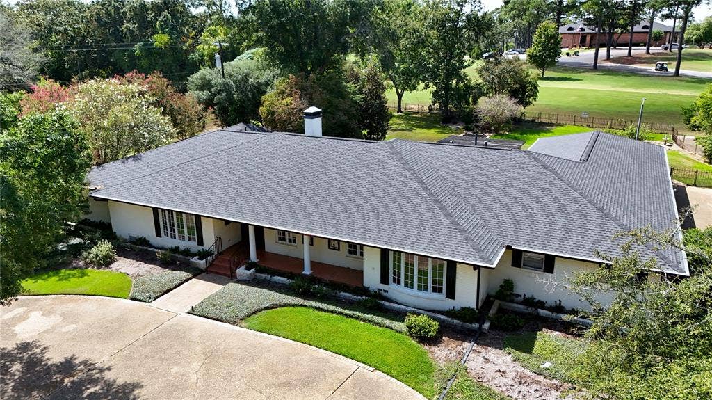 702 Mulberry Drive, Athens, TX 75751 Expansive asphalt shingle roof, bay window, manicured landscaping, concrete driveway, and covered front porch with columns
