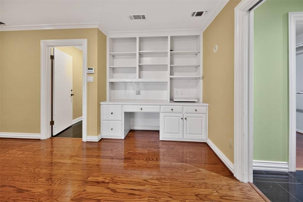 702 Mulberry Drive, Athens, TX 75751 Built-in white cabinetry with desk space and shelving, crown molding, and wood-finish flooring