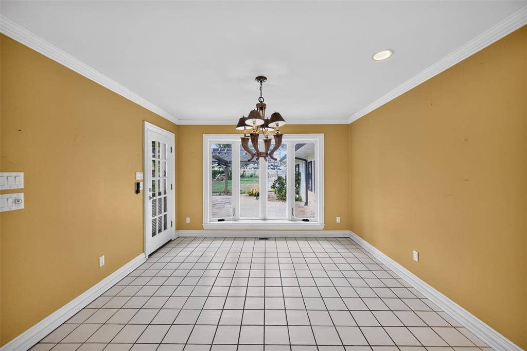 702 Mulberry Drive, Athens, TX 75751 Tile flooring, crown molding, a multi-pane glass door, recessed lighting, and a chandelier