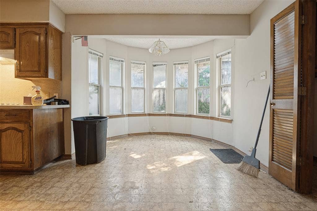 1901 Wedgewood Drive, Grand Prairie, TX 75050 Bay window feature with multiple panes, kitchen cabinetry with wood-finish doors, and louvered bifold doors