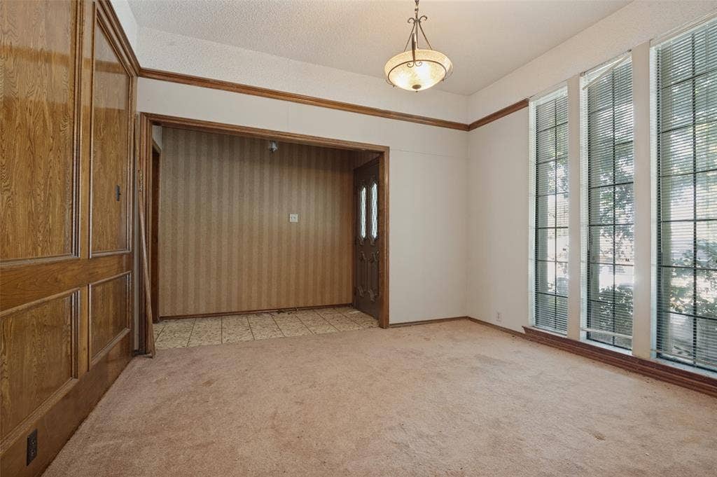 1901 Wedgewood Drive, Grand Prairie, TX 75050 Wood-paneled wall, recessed entry, full-light entry door with sidelights, three tall windows with blinds, and a traditional ceiling fixture