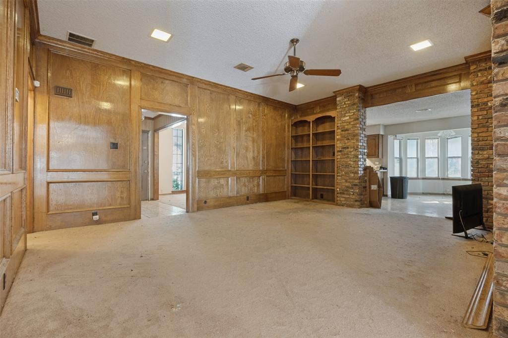 1901 Wedgewood Drive, Grand Prairie, TX 75050 Wood paneling and built-in shelving complement the brick-clad archway and structural columns