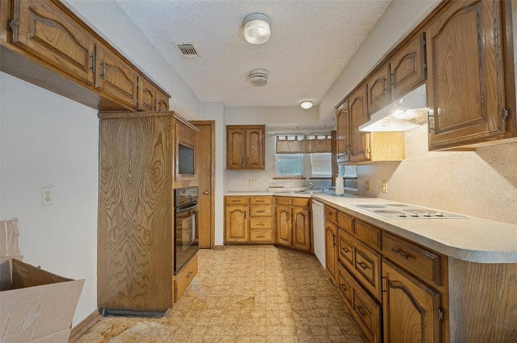 1901 Wedgewood Drive, Grand Prairie, TX 75050 Kitchen featuring wood cabinetry, white countertops, built-in oven, and a built-in microwave