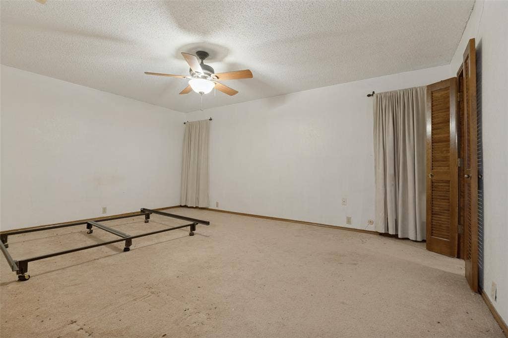 1901 Wedgewood Drive, Grand Prairie, TX 75050 Carpeted room with white walls, a ceiling fan with light fixture, and louvered bi-fold closet doors