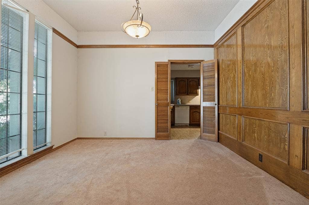 1901 Wedgewood Drive, Grand Prairie, TX 75050 Panel wood-finish wall, dual tall windows, wood-finish trim, and a built-in ceiling light fixture