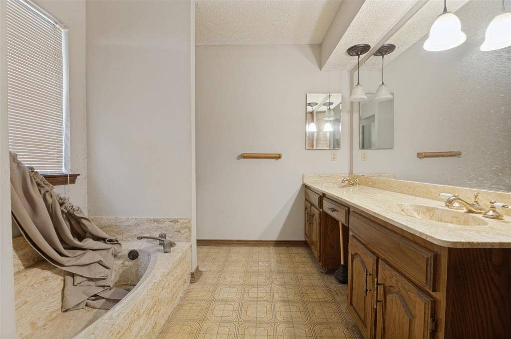 1901 Wedgewood Drive, Grand Prairie, TX 75050 Dual vanity with integrated sinks, stone-look countertop, and wood cabinetry