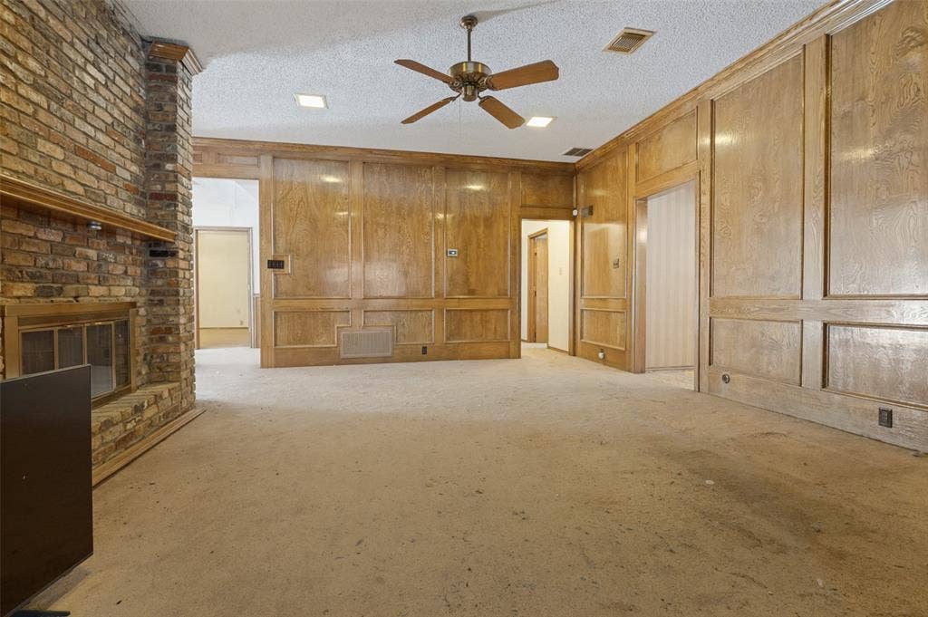 1901 Wedgewood Drive, Grand Prairie, TX 75050 Exposed brick fireplace, wood paneling, recessed lighting, and a ceiling fan