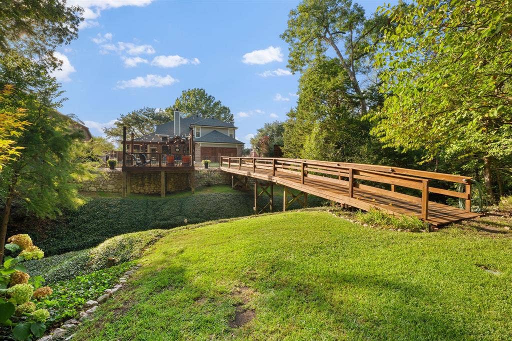 3202 Harbor Pointe Drive, Rowlett, TX 75088 Expansive backyard featuring a manicured lawn, lush ground cover, and mature trees