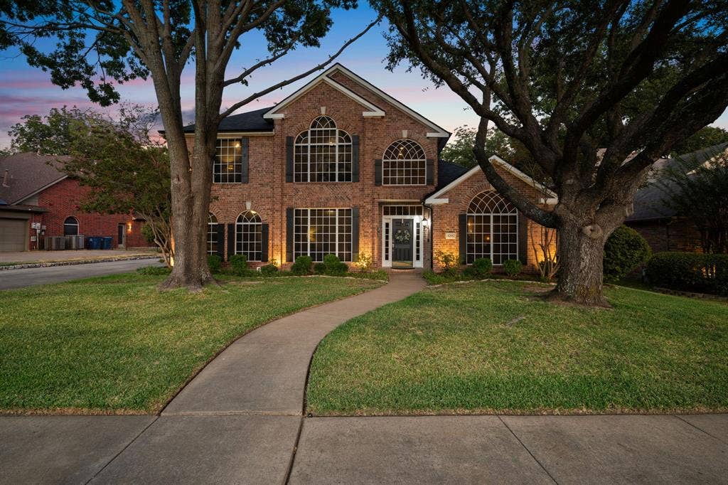 3202 Harbor Pointe Drive, Rowlett, TX 75088 Brick facade residence with arched windows, custom shutters, and a prominent front entrance