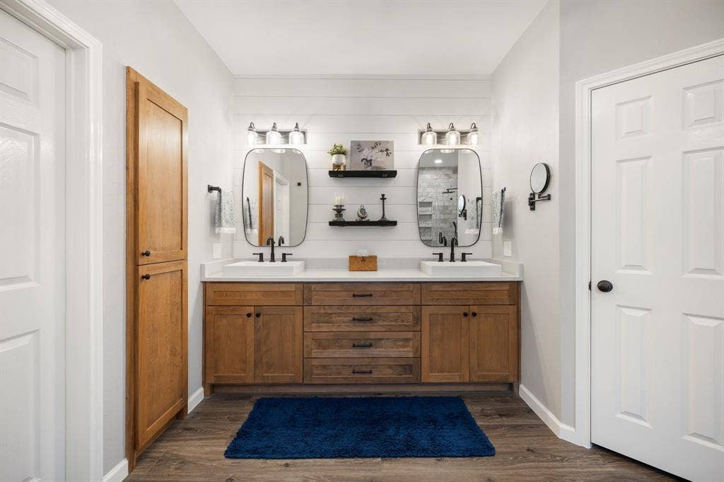 3202 Harbor Pointe Drive, Rowlett, TX 75088 Dual vanity with wood-finish cabinetry, rectangular vessel sinks, and matte black fixtures