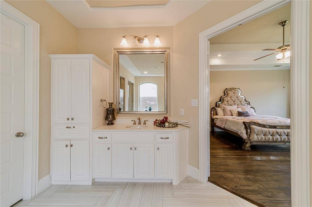 13018 Seattle Slew Street, Frisco, TX 75035 Vanity with white cabinetry, integrated sink, and wall-mounted mirror
