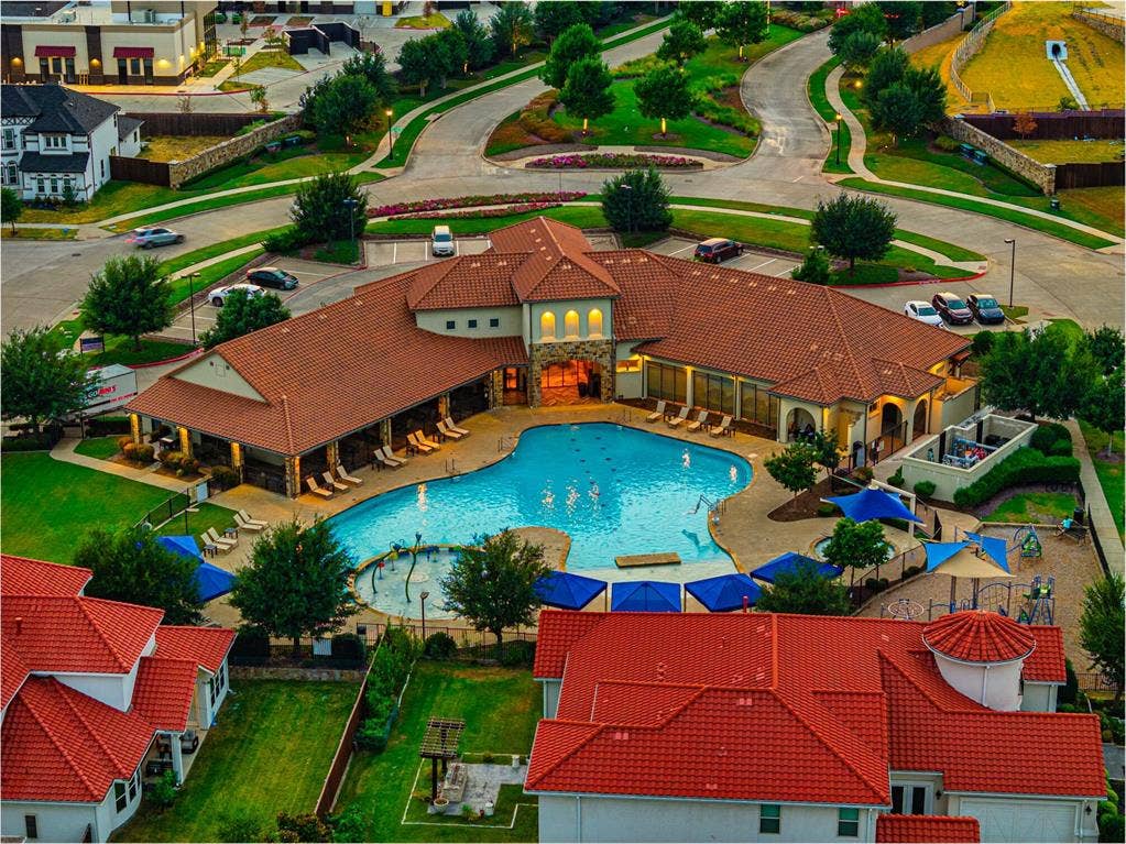 13018 Seattle Slew Street, Frisco, TX 75035 Community pool with multiple entry points, adjacent shaded lounge areas, and a children's splash pad