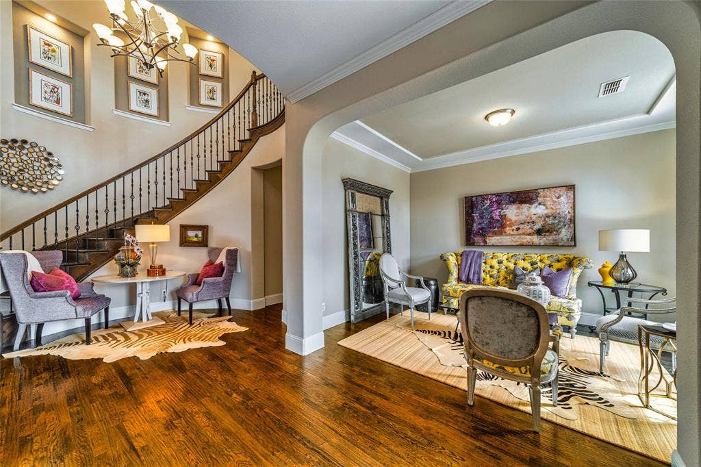 13018 Seattle Slew Street, Frisco, TX 75035 Hardwood flooring, curved staircase with wood banister, archway entry, crown molding, and recessed lighting