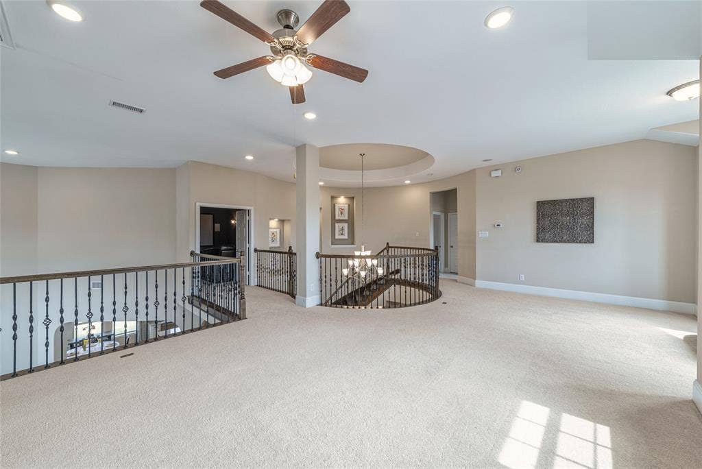 13018 Seattle Slew Street, Frisco, TX 75035 Spacious carpeted upper-level landing featuring a wood-finish ceiling fan, recessed lighting, and ornate wrought iron railings