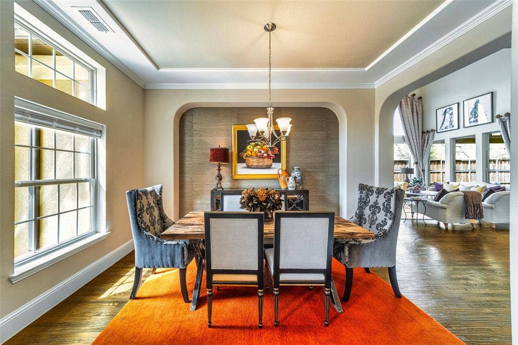 13018 Seattle Slew Street, Frisco, TX 75035 Hardwood flooring, arched doorways, crown molding, a tray ceiling, and a chandelier