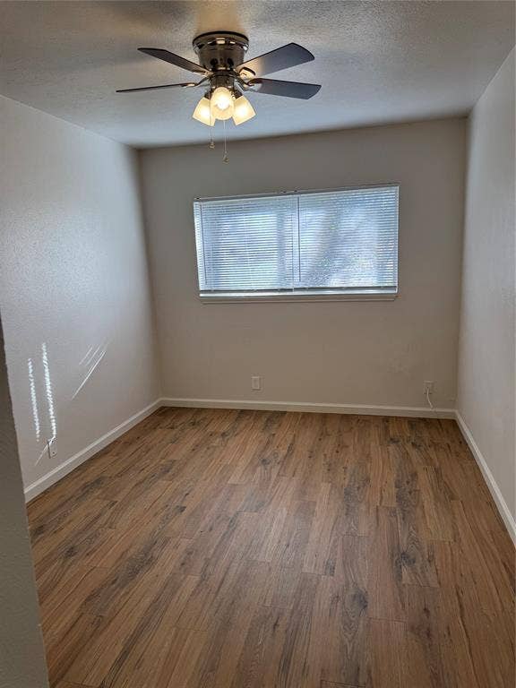1104-1106 Mulkey Lane, Denton, TX 76209 Wood-finish flooring throughout, ceiling fan with integrated lighting, and a window with horizontal blinds