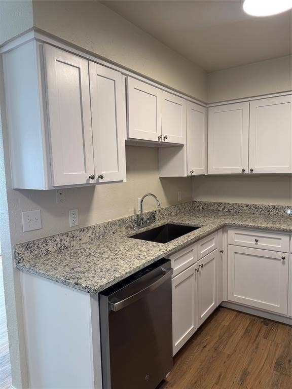 1104-1106 Mulkey Lane, Denton, TX 76209 White shaker-style cabinetry, patterned stone countertops, stainless steel dishwasher, undermount sink with gooseneck faucet, and wood-finish flooring