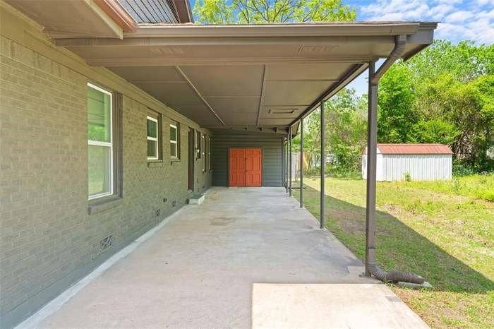2405 Monroe Street, Commerce, TX 75428 Expansive covered patio with concrete flooring, supported by metal columns