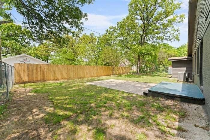 2405 Monroe Street, Commerce, TX 75428 Expansive backyard featuring a new privacy fence, chain link fence, and a concrete patio