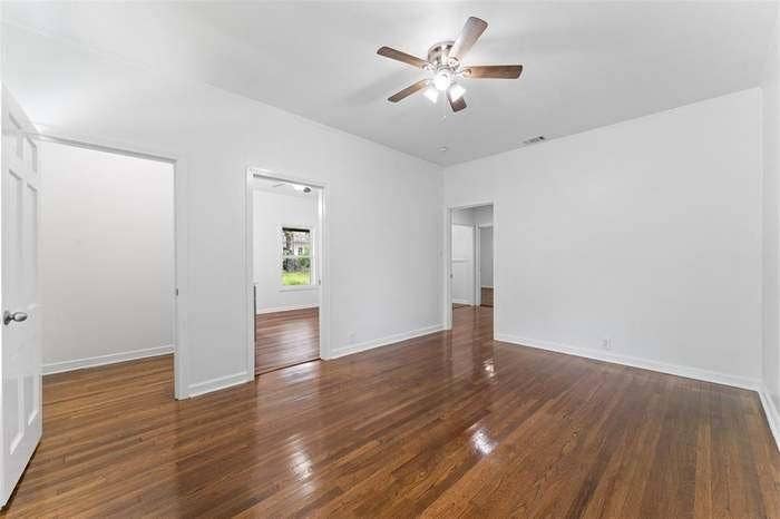 2405 Monroe Street, Commerce, TX 75428 Hardwood flooring throughout, ceiling fan with integrated lighting, white interior doors, and a neutral wall palette