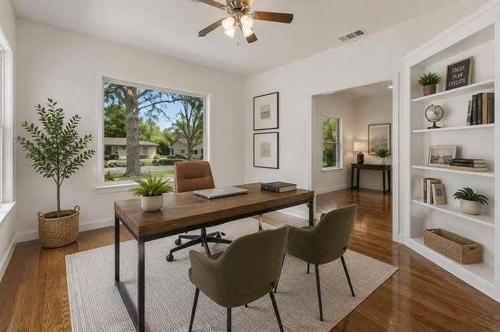 2405 Monroe Street, Commerce, TX 75428 Hardwood flooring, recessed built-in shelving, a ceiling fan, and large windows create a bright interior