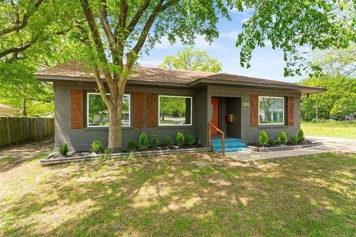 2405 Monroe Street, Commerce, TX 75428 Charcoal brick exterior with wood-finish shutters, a covered entry, and a contrasting bright blue front step