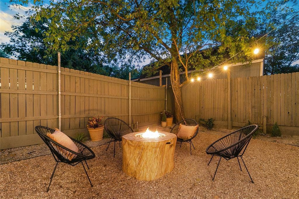 214 Short Street, McKinney, TX 75069 Gravel patio featuring a built-in fire pit, privacy fencing, and mature trees