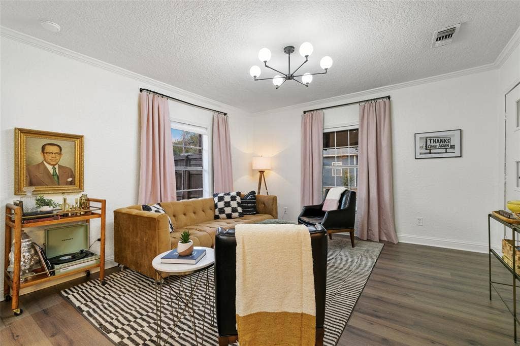 214 Short Street, McKinney, TX 75069 White wall finishes with crown molding, wood-finish flooring, and a modern chandelier