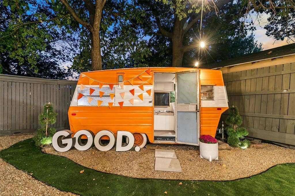 214 Short Street, McKinney, TX 75069 Enclosed private outdoor area featuring a vintage-style trailer, string lighting, and a fenced perimeter