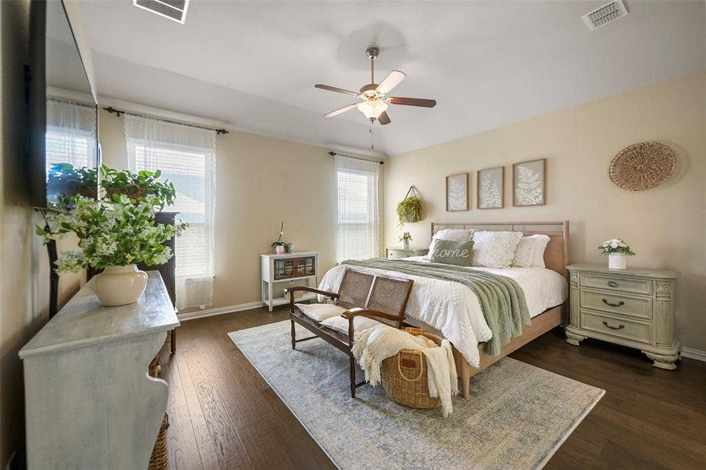 Wood-finish flooring, ceiling fan, and multiple windows with blinds