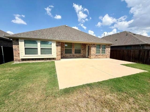 3806 Chicory Court, Melissa, TX 75454 Rear exterior featuring a brick facade, multiple windows, a large concrete patio, and a privacy fence