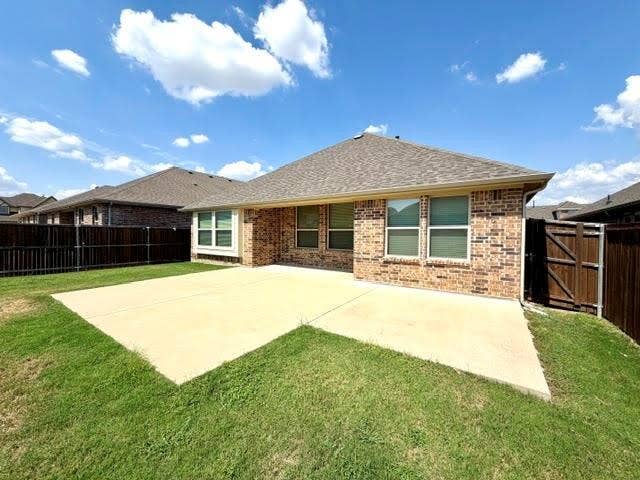 3806 Chicory Court, Melissa, TX 75454 Brick exterior with multiple windows, a large concrete patio, and a wood privacy fence