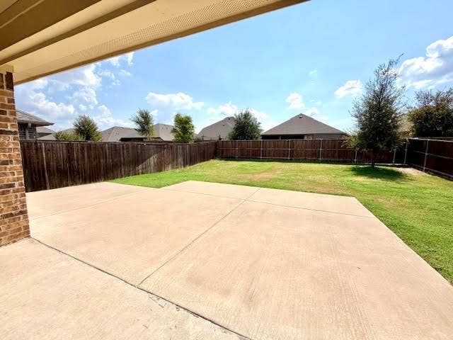 3806 Chicory Court, Melissa, TX 75454 Covered patio with a concrete surface, brick wall, and expansive lawn surrounded by a privacy fence