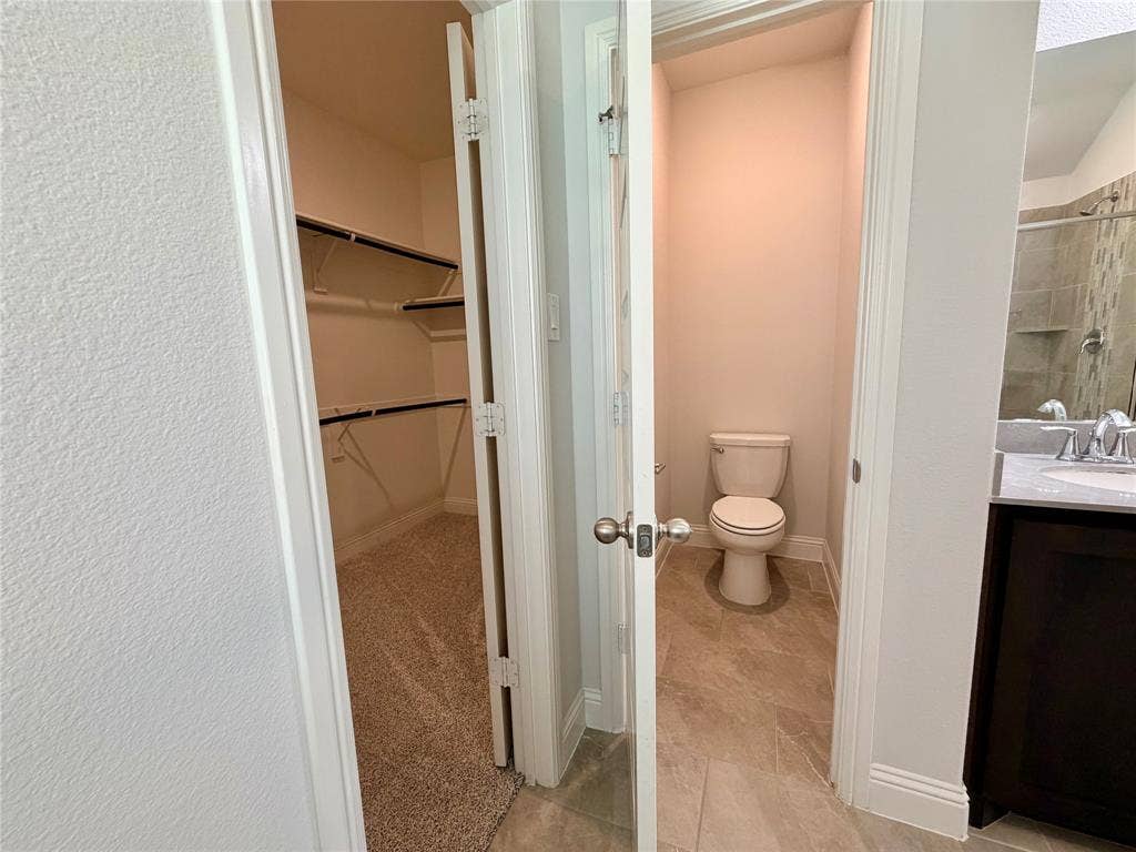 3806 Chicory Court, Melissa, TX 75454 This bathroom features a private, enclosed water closet area that is completely separated from the primary vanity and shower space for enhanced privacy and functionality.